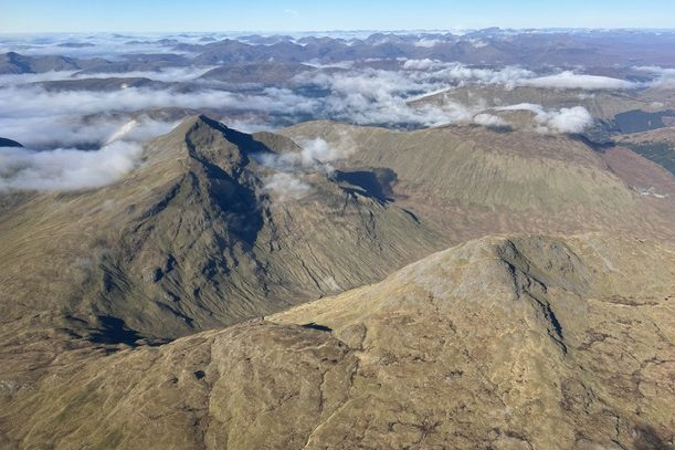 Pointed peaks rising above low cloud